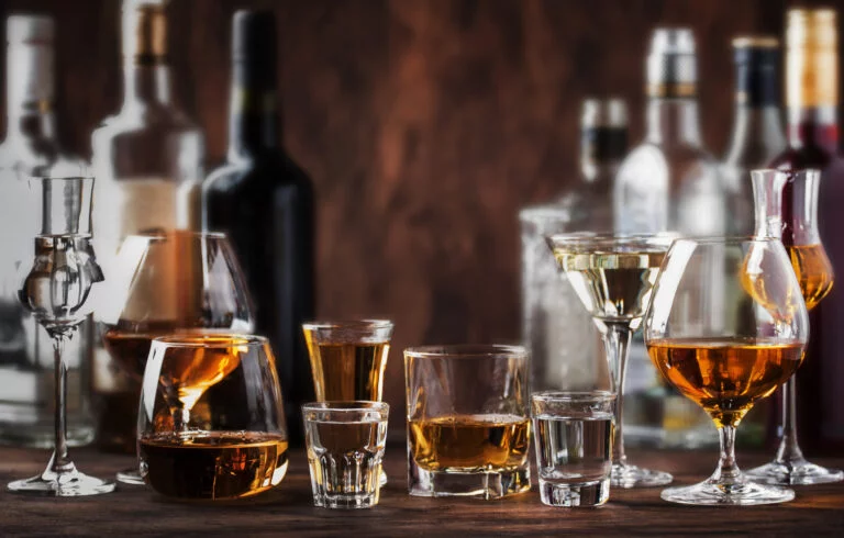 Strong Spirits Set. Hard alcoholic drinks in glasses in assortment: vodka, cognac, tequila, brandy and whiskey, grappa, liqueur, vermouth, tincture, rum. Vintage bar counter background, selective focus