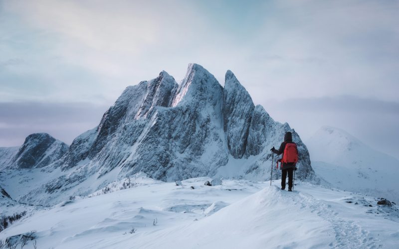 Mountaineer woman standing on top of Segla peak with majestic mountain in snowy on winter at Senja Mountaineer woman standing on top of Segla peak with majestic mountain in snowy on winter at Senja Island